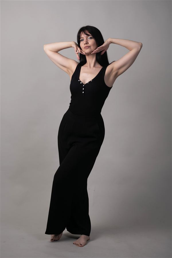 Full-length studio pose with arms raised